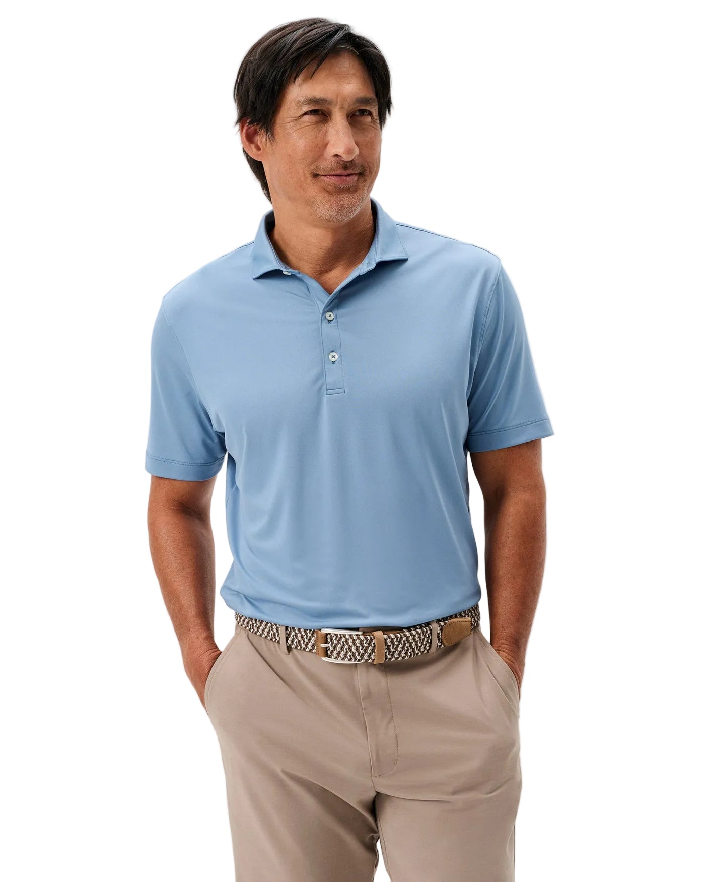 Man wearing a light blue polo shirt and beige pants on a plain background